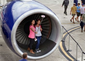 Two young visitors to the Blue Angels Homecoming Air Show on Saturday use a "selfie" stick and cell-phone camera to photograph themselves inside the front of a Delta Airlines Boeing 757 Pratt-Whitney engine, a photo opportunity afforded them by Delta Airlines employees.